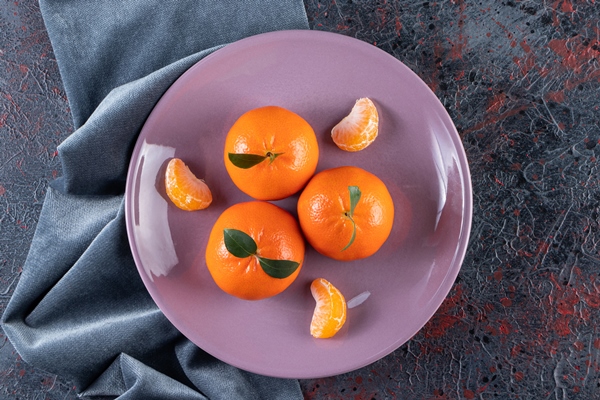 ripe mandarins with leaves placed on a purple plate - Пасха с фруктовым желе
