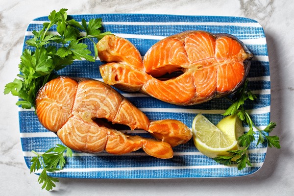 salmon steaks served with lemon wedges and parsley on a blue rectangular plate on a marble table horizontal view from above flat lay - Салат «Фасолька»