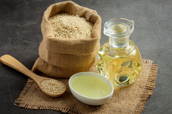 sesame oil and sesame seeds on dark background - Библия о пище