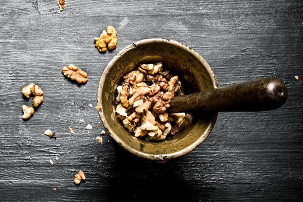 shelled walnuts in a mortar with pestle on black rustic table 1 - Постные блины со свёклой и орешками