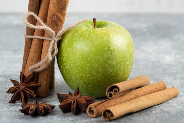 single green apple and cinnamon sticks on marble table - Постные запечённые блинчики с яблоками