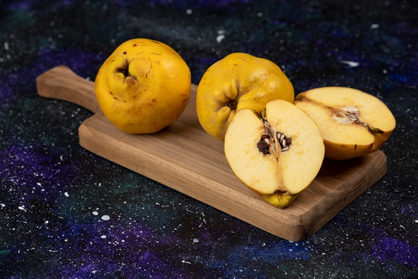 sliced and whole fresh quince fruits on wooden board 1 - Повидло из айвы