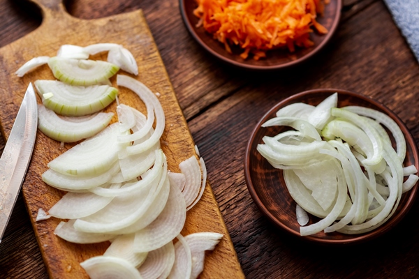 sliced onions and carrots on a dark wooden background ingredients preparation for cooking - Постные блины с картофельной начинкой