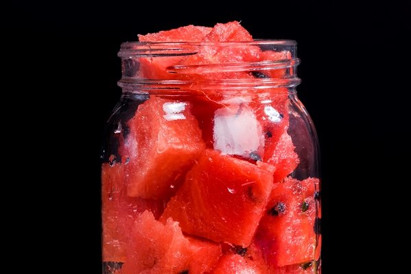 slices of red watermelon in a glass jar during breakfast delicious and juicy watermelon on a canned table - Маринованные арбузы