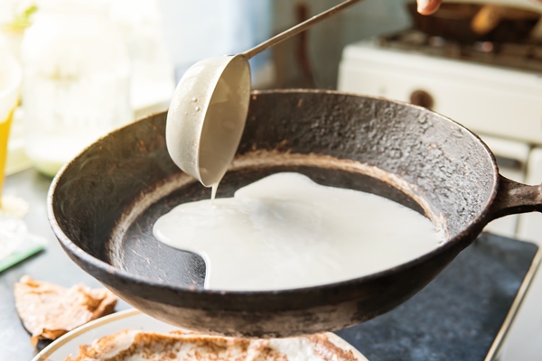 the batter for pancakes pour on a hot hot pan from the pilgrim home cooking food maslenitsa russian national holiday - Постные блинцы на рассоле