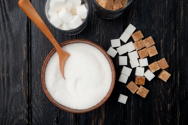 top view of different types and forms of sugar in a bowl and glasses on black wooden background - Консервированные сливы с имбирем