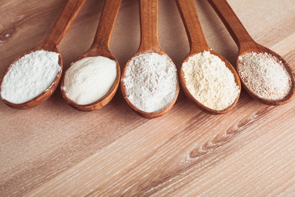 various types of flour in five wooden spoons - Постные гречневые блины на кипятке с луком
