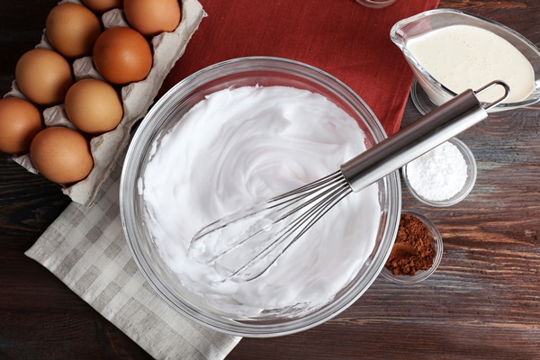 whipped egg whites for cream on wooden table top view - Кулич миндальный