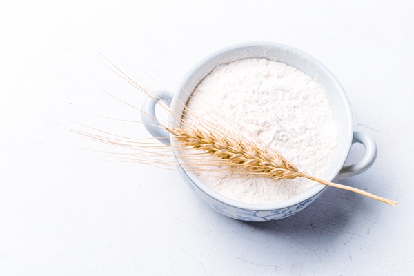 whole flour in bowl with wheat ears on white background - Постные яблочные блины на соевом молоке