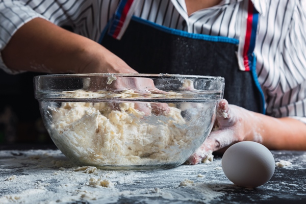 woman kneading dough in glass bowl - Пасхальный хлеб по-голландски