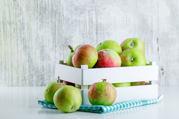 apples in a wooden box with picnic cloth side view on white and grungy - Яблоки печёные с брусникой