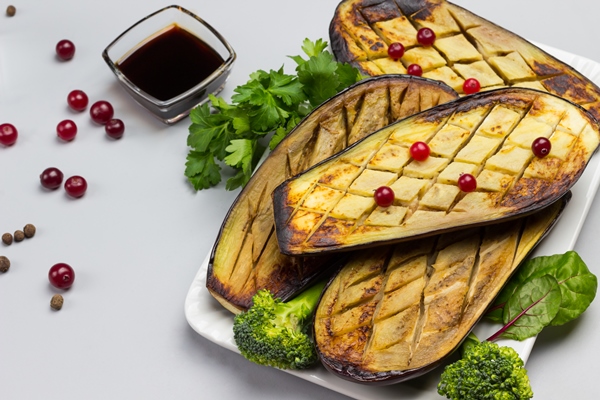 baked eggplant with with parsley and broccoli sauce in bowl and cranberries on table gray background top view - Перец с начинкой из баклажанов