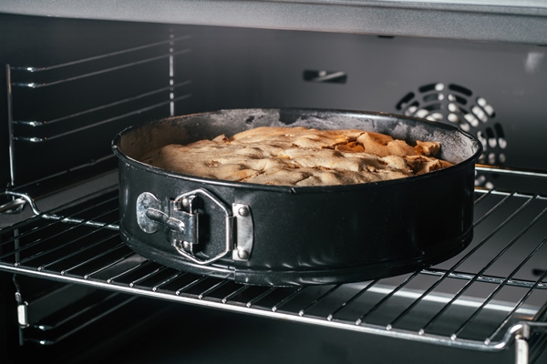 baking dish with apple pie stands in black oven homemade seasonal bakery - Торт постный