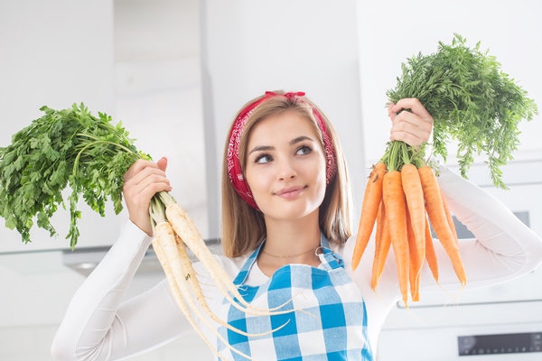 beautiful girl holding bunches of fresh carrots and parsley in the kitchen - Суп грибной с рисом, постный стол