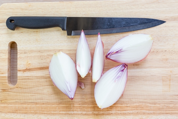 big onion and slices on wooden cutting board - Рагу из картофеля с красным сладким перцем и капустой