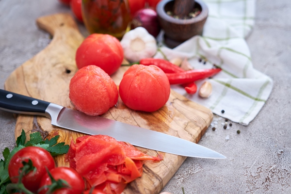 blanched peeled tomatoes on wooden cutting board at domestic kitchen 1 - Овощной смузи с томатом и огурцом