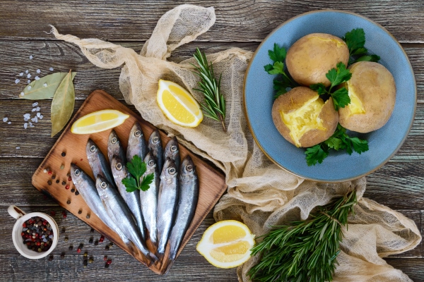 boiled unpeeled potatoes in skins a small salted fish of baltic herring sprats on a wooden table top view flat lay - Пирог с салакой и картофелем