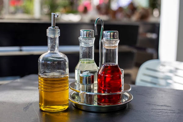 bottles of olive oil balsamic vinegar and wine stand on black table - Кисло-сладкий постный соус