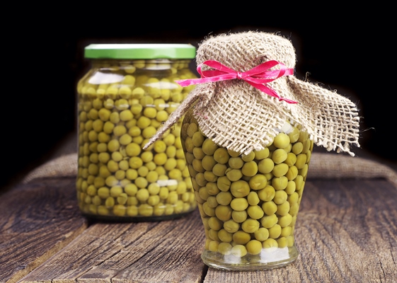 canned green peas in glass jar on wooden table - Картофельное рагу с овощами