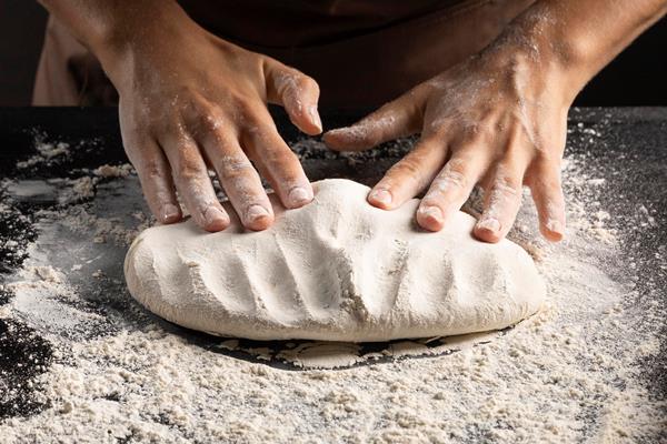 chef kneading dough on the table - Крендели постные