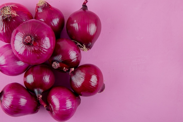 close up view of red onions on left side and purple background with copy space - Пирог «Луковник» постный