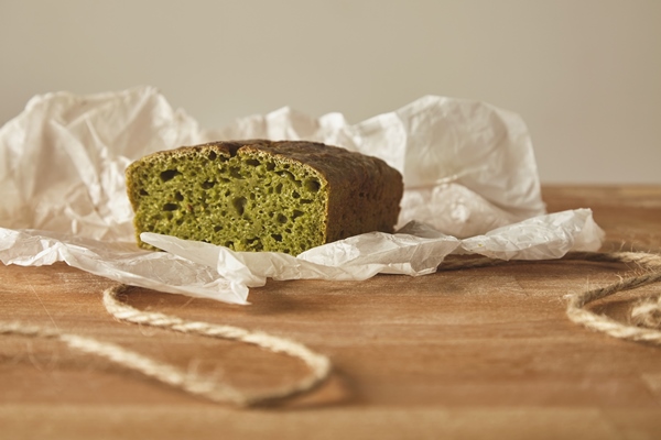 closeup healty diet green bread from spinash dough on craft paper isolated on wooden board - Полезный хлеб с крапивой