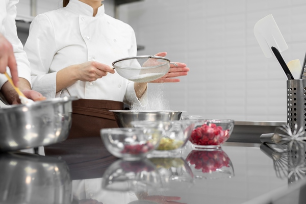 closeup of a pastry chefs hands a man and a woman in a professional kitchen prepare a sponge cake - Торт постный
