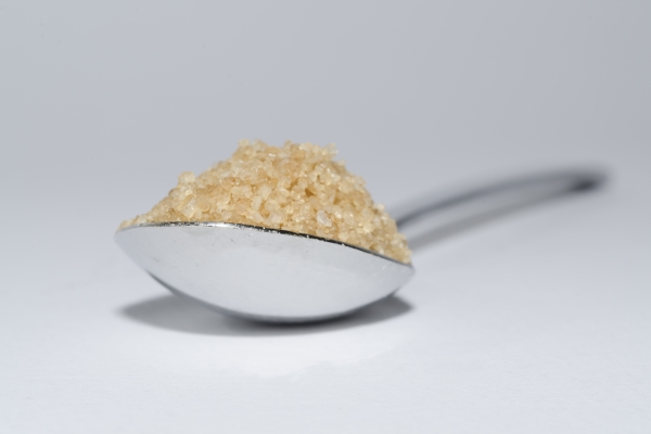 closeup of a spoonful of brown sugar on white surface - Фасоль пёстрая отварная с пряностями