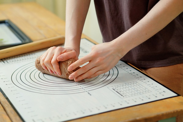 closeup on female hands that knead the dough for gingerbread cookies on a baking mat - Медовые пряники