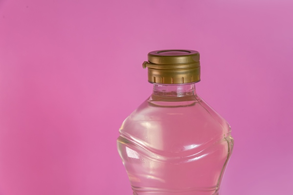 container of vinegar on the pink background - Заправка горчичная с чесноком