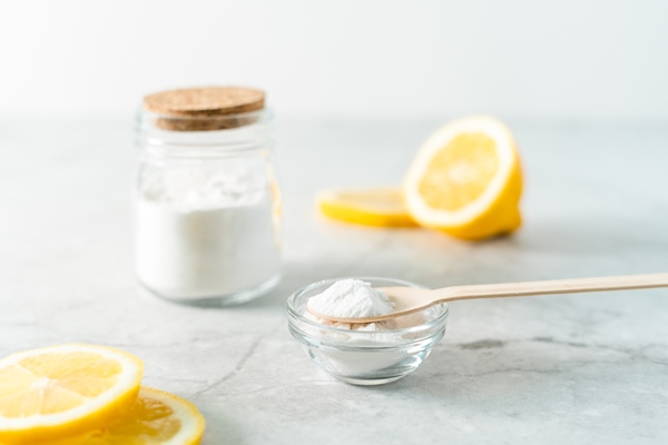 eco friendly natural cleaners jar with baking soda lemon and wooden spoon on marble table background - Оладьи с пряностями и специями