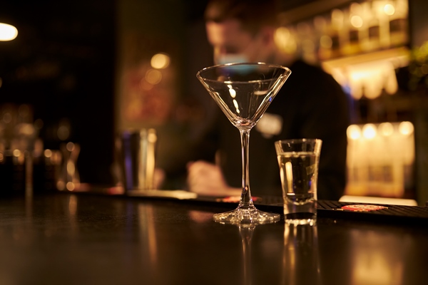 empty martini glass and shot glass on bar counter on yellow background - Начинка ромовая для пирожков с яблоками