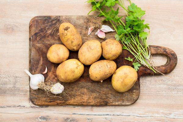flat lay raw potatoes on wooden board - Картофель ломтиками, запечённый с селёдкой