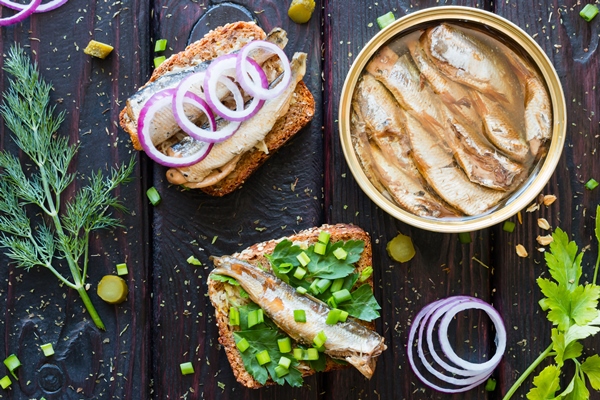 grain bread with sardines and greens next to the bank sprats - Бутерброд с копчёной рыбой