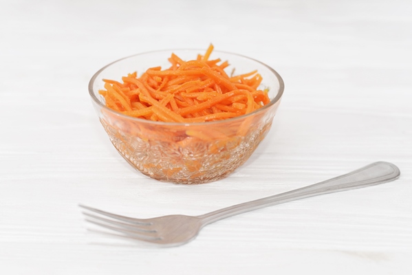 grated raw carrots in korean style korean carrot in the white bowl isolated on white background - Салат "Осенний"