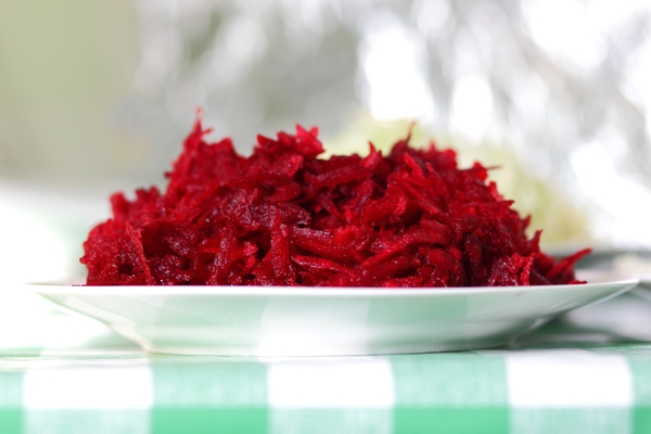 grated red beets on a plate on a tablecloth in a home kitchen healthy food concept closeup - Напиток свекольный без сахара
