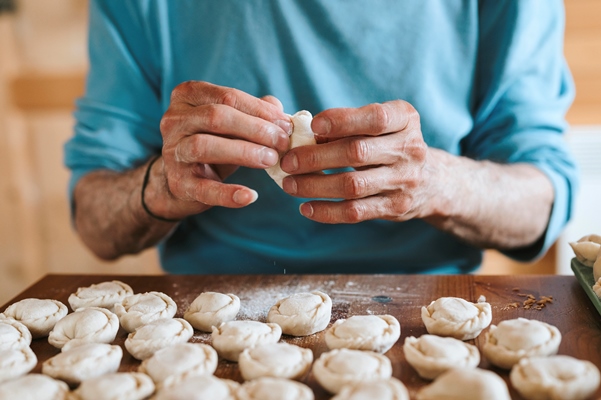 hands of senior man cooking and molding small homemade uncooked dumplings - Постный суп грибной с галушками