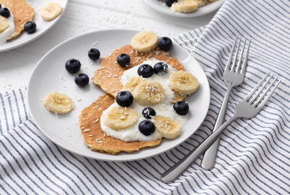 homemade oatmeal pancakes with yogurt fresh blueberry and banana at white wooden table - Оладьи из геркулесовой каши