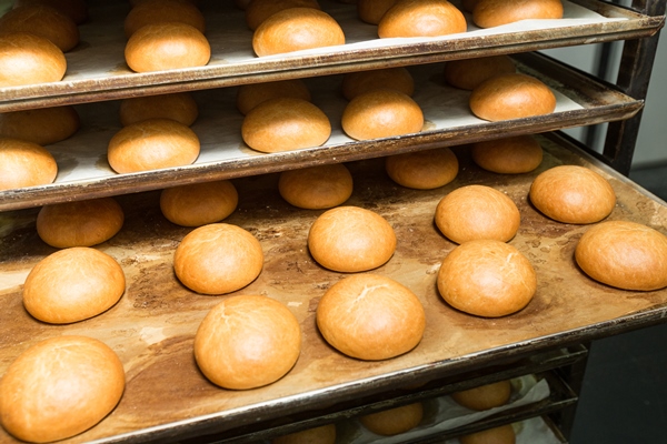 just baked hot small sweet buns on a trays on a bread production line - Булки постные