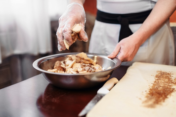 male chef sprinkle the dough with cinnamon - Штрудели с яблоками