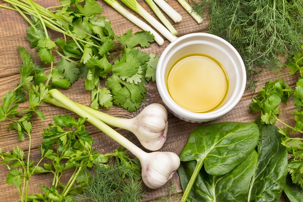 olive oil in white bowls spinach garlik cilantro parsley on table light wooden background top view - Ореховая паста кедровая