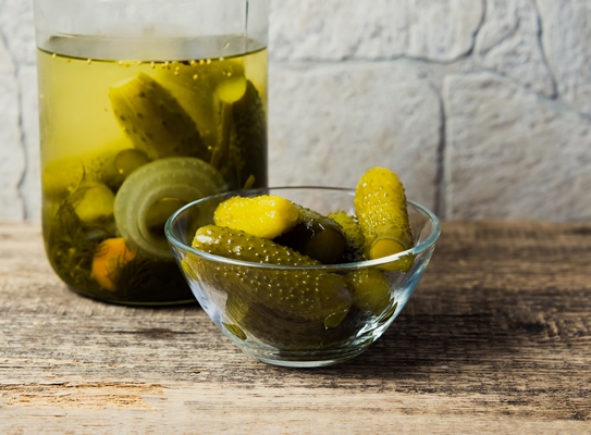 pickled cucumbers in a bowl on a wooden rustic table and a jar of pickles - Салат из свёклы с огурчиками и луком