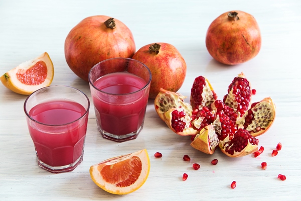 pomegranate liqueur in glasses and whore pomegranates on wooden table - Салат из граната и лука