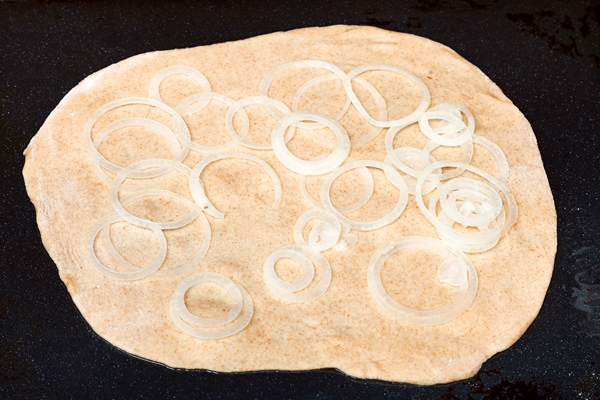 raw onion rings on sheet of dough - Пирог с картофелем