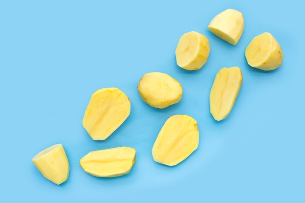 raw peeled potatoes on blue background - Картофельные ломтики с грибами