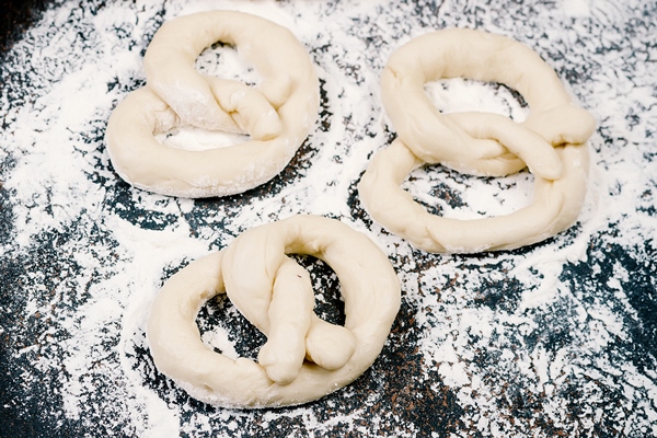 raw pretzel and ingredients eggs flour and ears of wheat - Постный именинный крендель