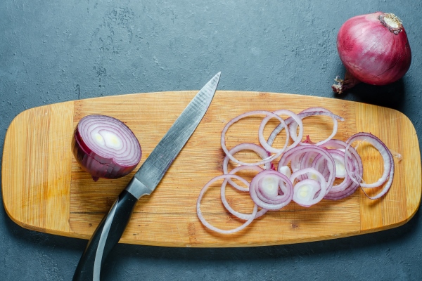red onion sliced the process of cooking on a yellow cutting board - Витаминный перекус