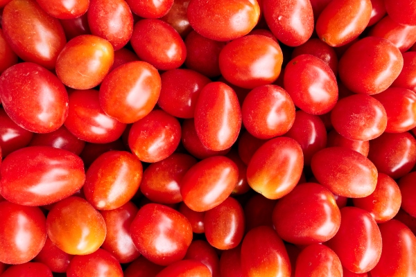 red ripe organic tomatoes at market may be used as background - Картофельный салат с рисом и рыбой