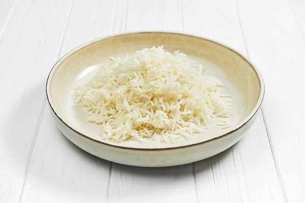 rice porridge in a plate on a white wooden background - Рис холодный с апельсинами