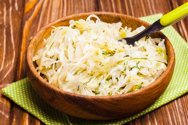 shredded fresh cabbage with dill in a wooden bowl - Салат картофельный с капустой